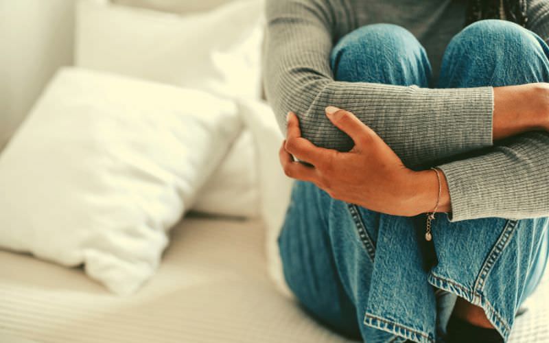 Stressed person sitting on a bed